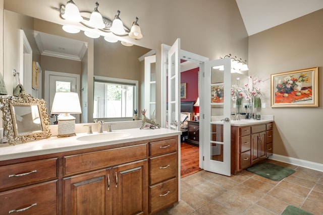 bathroom featuring ornamental molding, tile patterned flooring, vanity, and vaulted ceiling