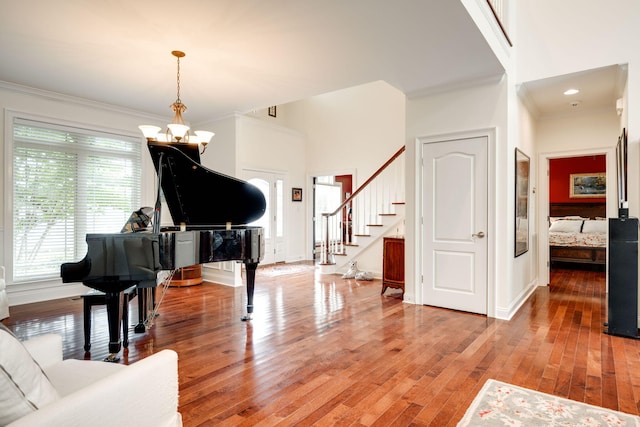 interior space with wood-type flooring, an inviting chandelier, and crown molding