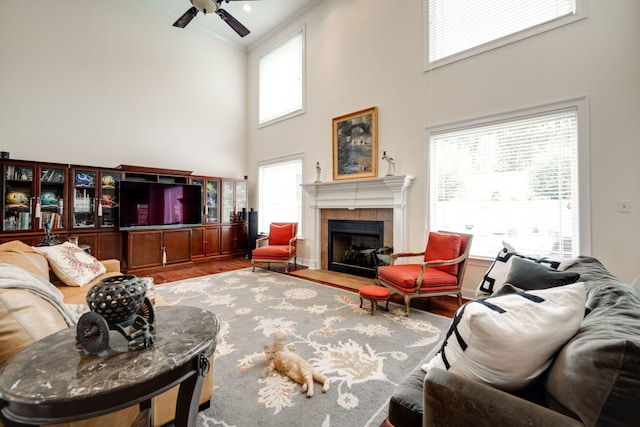 living room with a tile fireplace, a healthy amount of sunlight, hardwood / wood-style floors, and ceiling fan