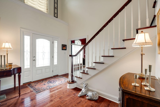 foyer entrance with a towering ceiling and hardwood / wood-style floors