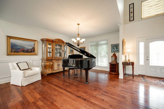 misc room featuring ornamental molding, dark wood-type flooring, and a notable chandelier