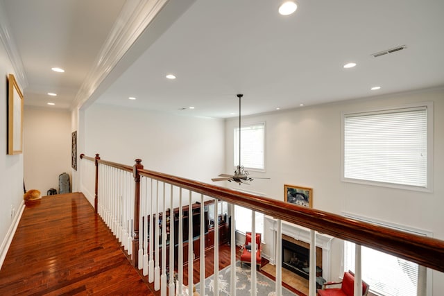 hall featuring baseboard heating, dark wood-type flooring, and crown molding