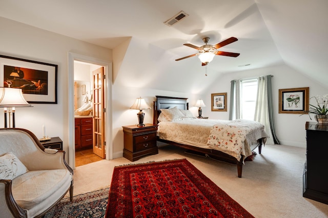 bedroom with ceiling fan, lofted ceiling, ensuite bath, and light carpet