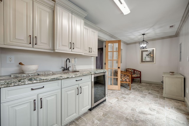 kitchen featuring pendant lighting, beverage cooler, white cabinetry, an inviting chandelier, and ornamental molding