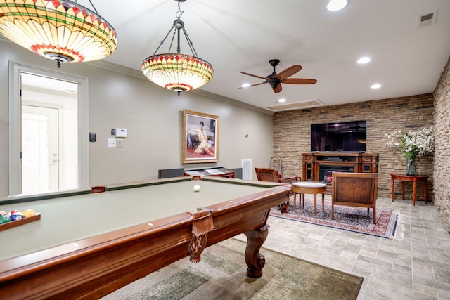 game room with pool table, a fireplace, ornamental molding, and ceiling fan