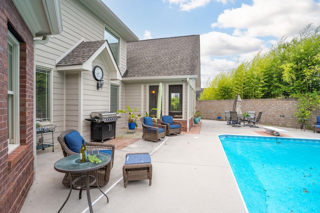 view of pool featuring a patio, area for grilling, and a diving board