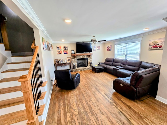 living room featuring crown molding, a fireplace, hardwood / wood-style flooring, and ceiling fan