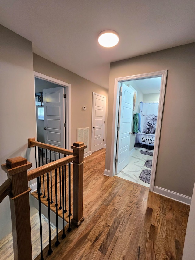 corridor with hardwood / wood-style floors