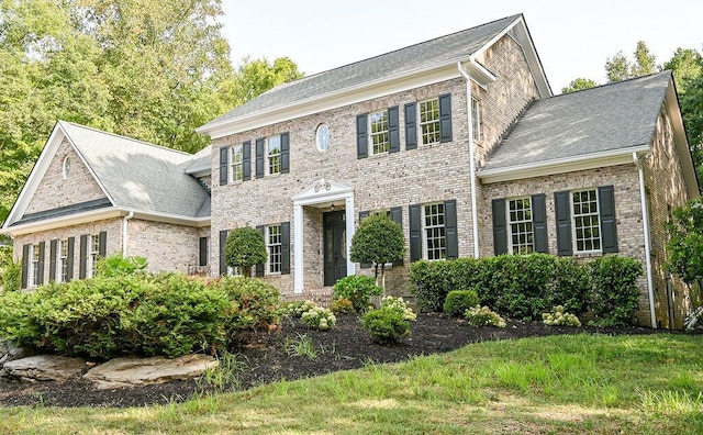 view of front of house with brick siding and a shingled roof