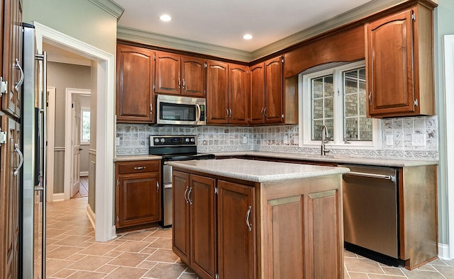 kitchen with a kitchen island, stainless steel appliances, sink, and tasteful backsplash