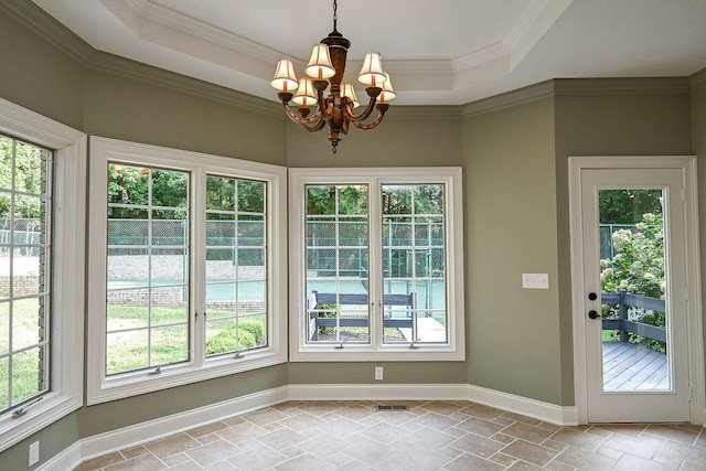 entryway featuring ornamental molding, a raised ceiling, and an inviting chandelier