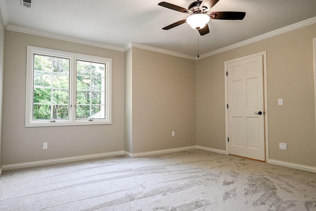 spare room featuring light carpet, baseboards, ornamental molding, and a ceiling fan