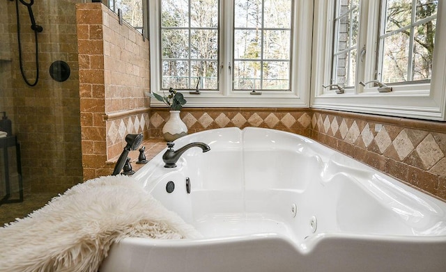 bathroom with a tub with jets and a wealth of natural light