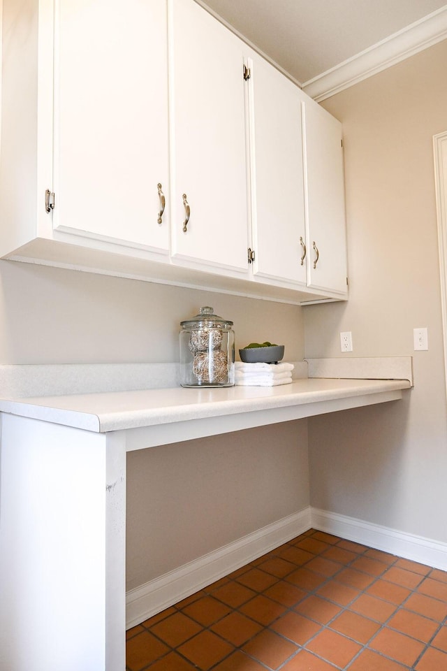 laundry room with ornamental molding, tile patterned flooring, and baseboards