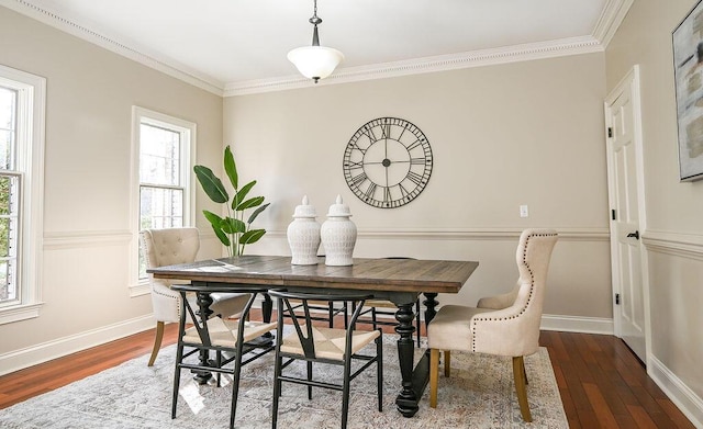 dining space featuring baseboards, ornamental molding, and wood finished floors