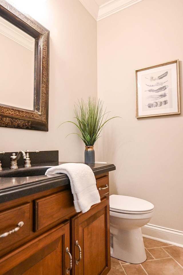 half bath with baseboards, crown molding, vanity, and toilet