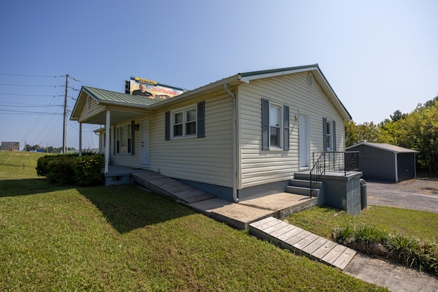 view of home's exterior featuring a storage shed, a yard, and covered porch