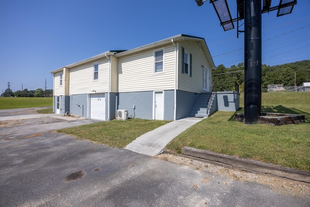 view of side of home with ac unit, a yard, and a garage