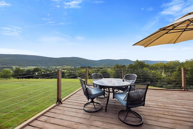 wooden terrace with a mountain view and outdoor dining area