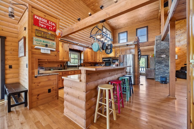 kitchen with wood ceiling, light countertops, freestanding refrigerator, and light wood-style floors