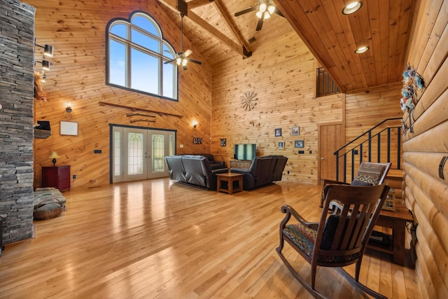 living area with stairs, a ceiling fan, wood finished floors, and wooden ceiling