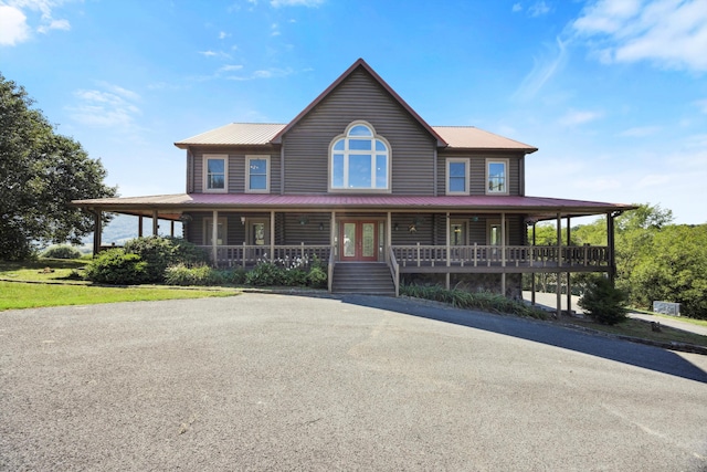 farmhouse featuring a porch, french doors, and metal roof