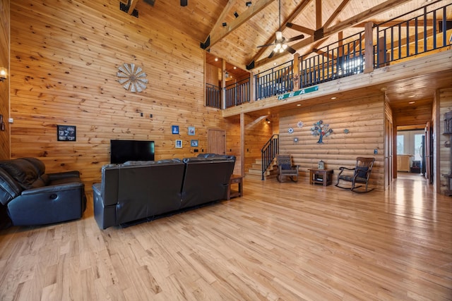 living area with vaulted ceiling with beams, stairway, wood ceiling, wood finished floors, and a ceiling fan