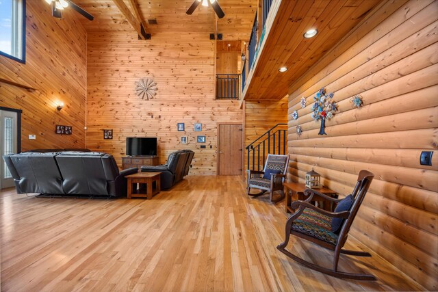 living room with beam ceiling, wooden ceiling, light wood-style floors, and ceiling fan