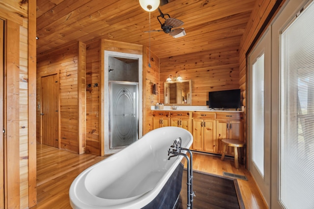 bathroom with a freestanding tub, a stall shower, wood ceiling, and wood finished floors