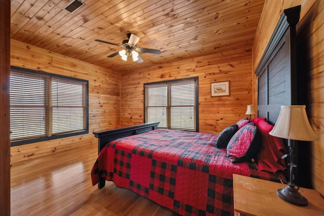 bedroom with visible vents, multiple windows, wood ceiling, and wood finished floors