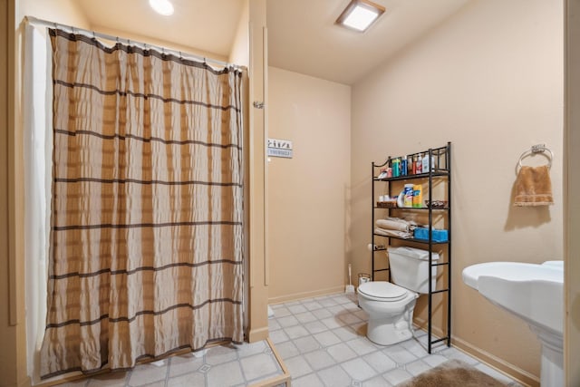 full bathroom with a shower with curtain, toilet, baseboards, and a sink