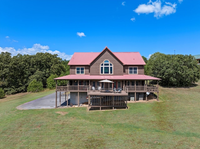 back of property with a deck, a yard, and metal roof