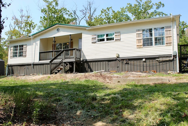 rear view of house featuring a yard