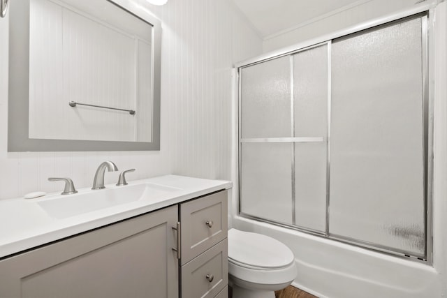 full bathroom featuring vanity, bath / shower combo with glass door, and toilet