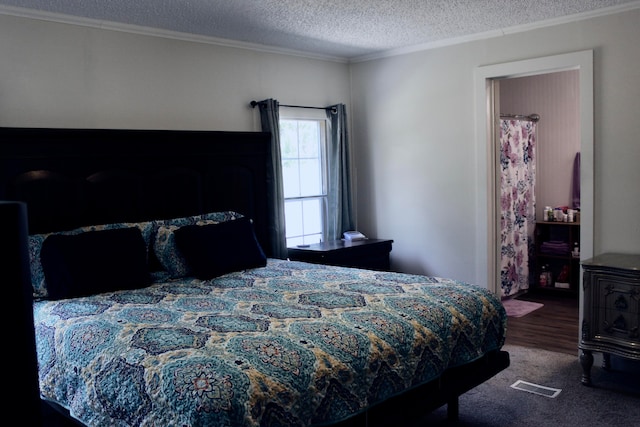 bedroom with ornamental molding, a textured ceiling, and dark colored carpet