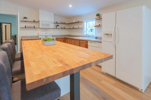 kitchen featuring wooden counters, light wood-type flooring, sink, and white appliances