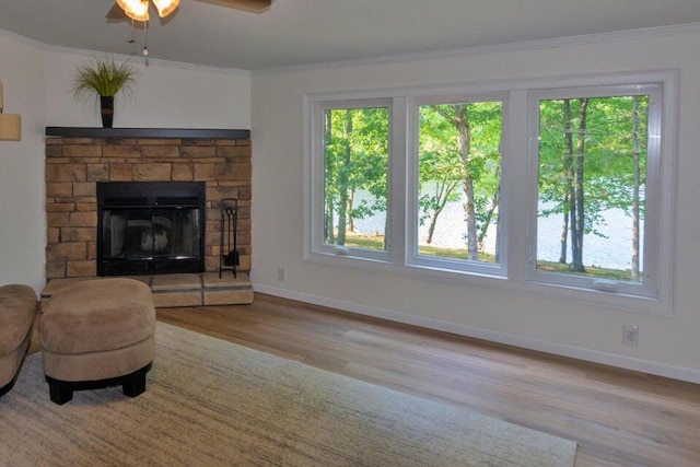 unfurnished living room featuring ceiling fan, a wealth of natural light, a fireplace, and light hardwood / wood-style floors