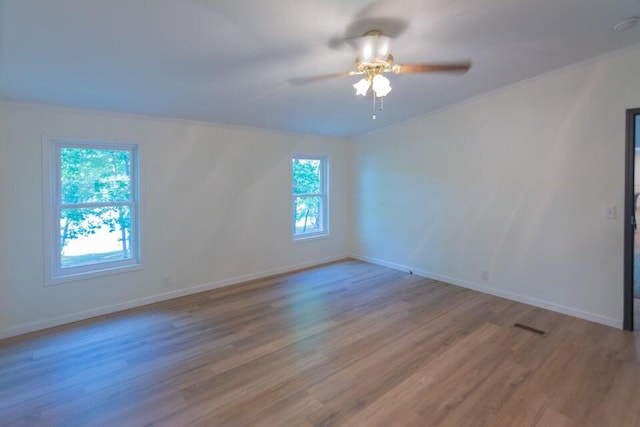 empty room with ceiling fan and light hardwood / wood-style floors