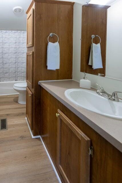 bathroom with vanity, toilet, and hardwood / wood-style floors