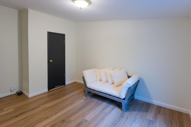 living area featuring ornamental molding and wood-type flooring