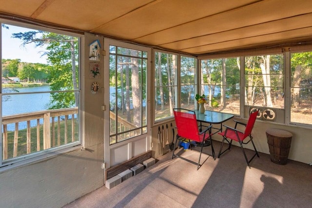 sunroom featuring a water view