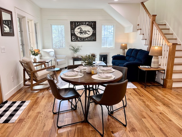 dining room featuring wooden walls and light hardwood / wood-style flooring