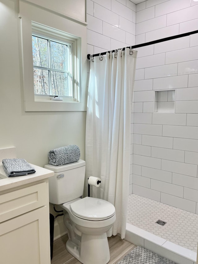 bathroom featuring hardwood / wood-style flooring, toilet, vanity, and a shower with shower curtain