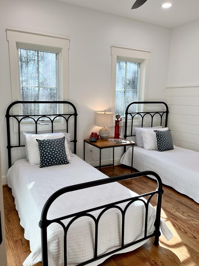 bedroom featuring multiple windows, hardwood / wood-style floors, and ceiling fan