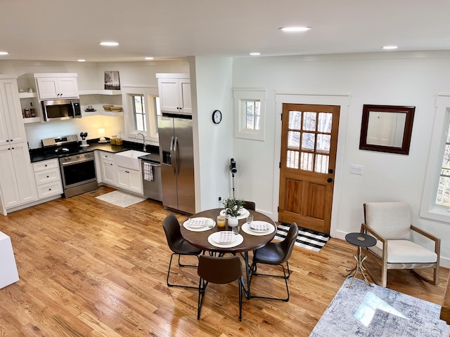 kitchen featuring white cabinetry, sink, stainless steel appliances, and light hardwood / wood-style floors