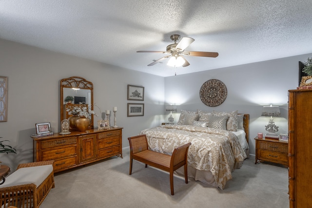 carpeted bedroom featuring ceiling fan and a textured ceiling