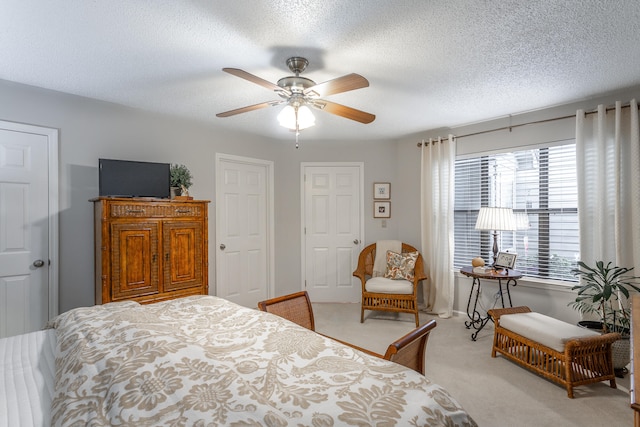 bedroom featuring ceiling fan, a textured ceiling, and carpet floors