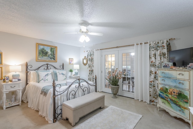 bedroom with a textured ceiling, light colored carpet, access to outside, and ceiling fan