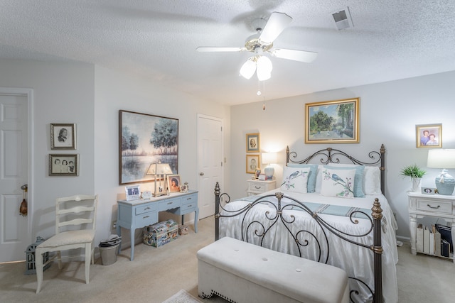 carpeted bedroom with a textured ceiling and ceiling fan