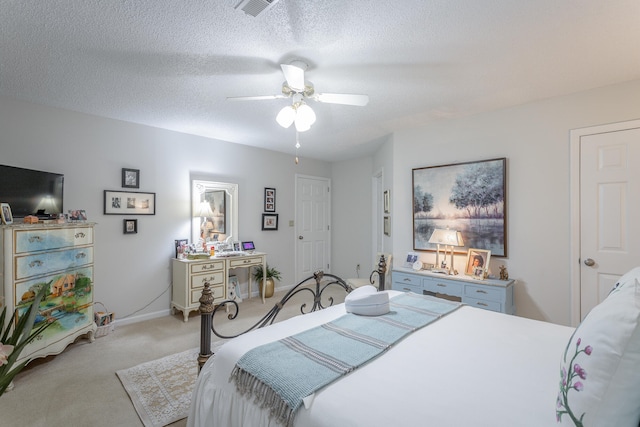 carpeted bedroom with a textured ceiling and ceiling fan